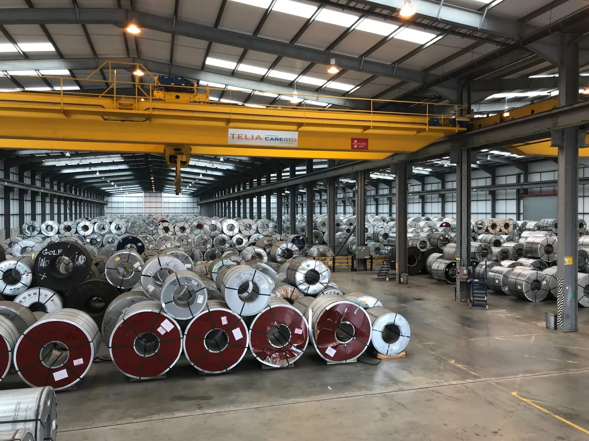Automated crane handling coils at a toll processing facility