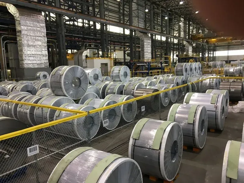 Coils stacked several high under one crane, using the full height of the bay