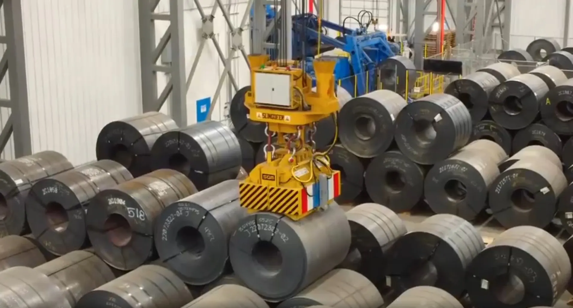 Coil magnet handling steel coils in a storage area